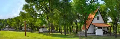 a small white house in a field with trees at Cabañas Juan Salvador in Los Reartes