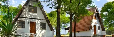 a small white house with a brown roof at Cabañas Juan Salvador in Los Reartes
