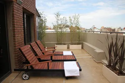a balcony with two chairs and a table at Sol de Piedra Apart, Suites & Spa in Cordoba