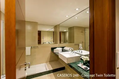 a bathroom with a sink and a large mirror at Caseros 248 Hotel in Cordoba