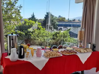 a table with plates of food on a red table at Gran Hotel Las Lajas in Villa Carlos Paz