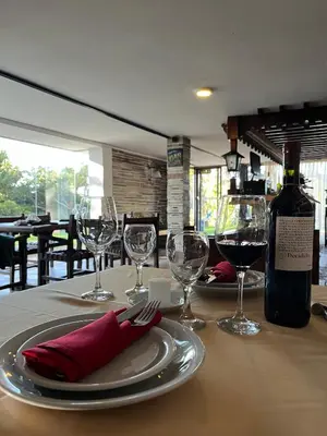 a table with wine glasses and a bottle of wine at Gran Hotel Las Lajas in Villa Carlos Paz