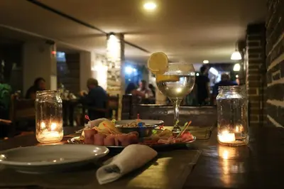 a table with a plate of food and a glass of wine at Gran Hotel Las Lajas in Villa Carlos Paz
