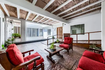 a living room with red furniture and windows at Gran Hotel Las Lajas in Villa Carlos Paz