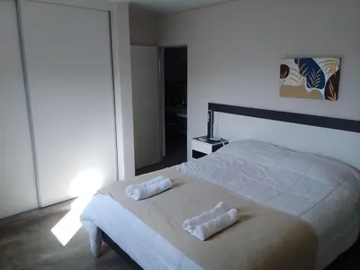 a bedroom with a bed with two towels on it at ALTOS DEL MOLLE en VCP predio con solo 2 cabañas in Villa Carlos Paz