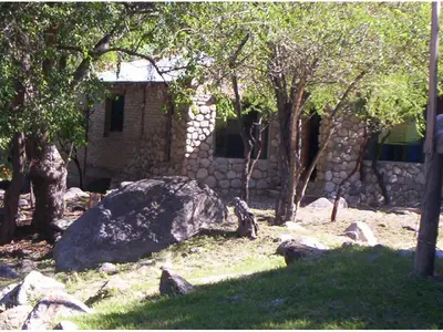 a rock and trees in front of a building at Cabanas Las Achiras in San Javier
