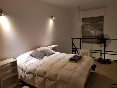 a bedroom with a bed and a fan in it at Departamento Loft VCP in Villa Carlos Paz