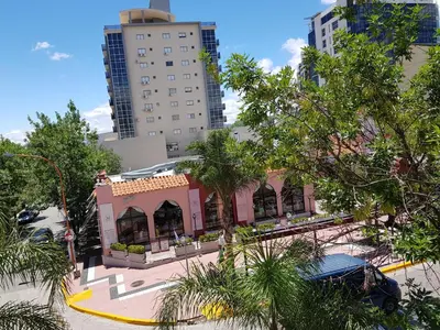 a small pink building in the middle of a city at Departamento Loft VCP in Villa Carlos Paz