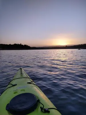 a kayak on a body of water with the sunset at Hermosa casa en Potrero de Garay in Potrero de Garay