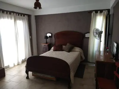 a bedroom with a bed and two windows at Hermosa casa en Potrero de Garay in Potrero de Garay