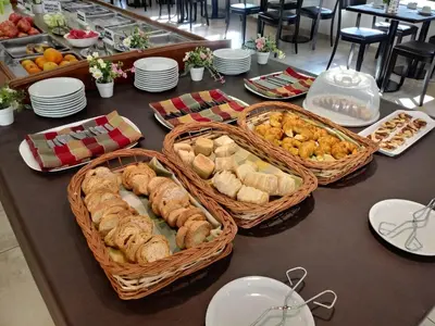 a table with baskets of bread and pastries on it at Hotel Hurlingham in Villa Carlos Paz