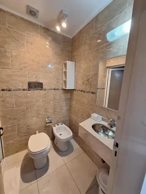 a bathroom with a toilet and a sink at Hotel Hurlingham in Villa Carlos Paz