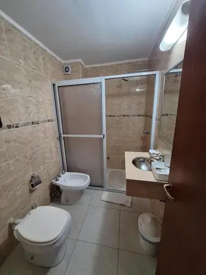a bathroom with a toilet and a shower and a sink at Hotel Hurlingham in Villa Carlos Paz