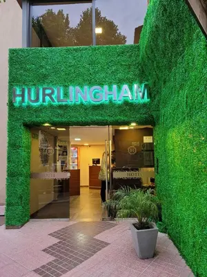 a green ivy covered storefront of a building at Hotel Hurlingham in Villa Carlos Paz