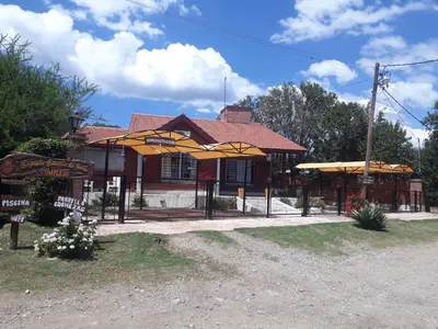 a building with umbrellas in front of it at Complejo Sagrado Corazón in Merlo