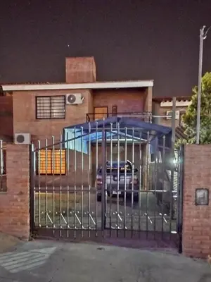 a gate in front of a house at night at casa villa suiza in Villa Carlos Paz