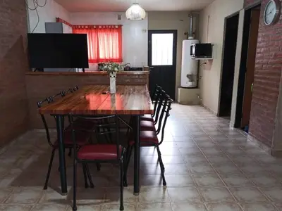 a dining room with a large wooden table and chairs at casa villa suiza in Villa Carlos Paz