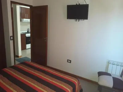 a bedroom with a bed and a television on the wall at Dpto centrico in Villa Carlos Paz