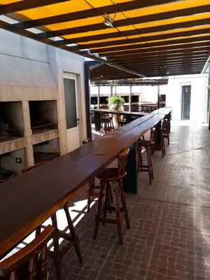a long wooden table in a restaurant with chairs at Dpto centrico in Villa Carlos Paz