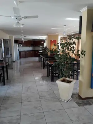 a restaurant with tables and chairs and a plant on the floor at Dpto centrico in Villa Carlos Paz