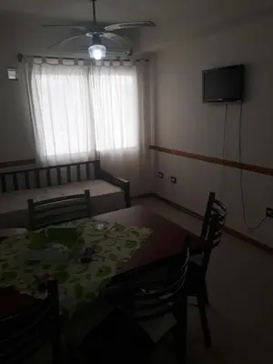 a dining room with a table and chairs and a television at Dpto centrico in Villa Carlos Paz