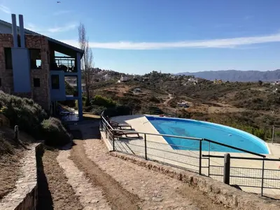 a large swimming pool next to a building at casa del lago -villa carlos paz in Villa Carlos Paz