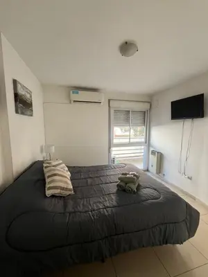 a bedroom with a large bed and a flat screen tv at Jardines del Boulevard in Cordoba