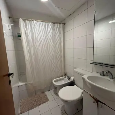 a white bathroom with a toilet and a sink at Jardines del Boulevard in Cordoba