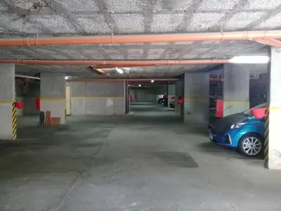 a parking garage with a blue car parked in it at Departamento en Carlos Paz para familias in Villa Carlos Paz