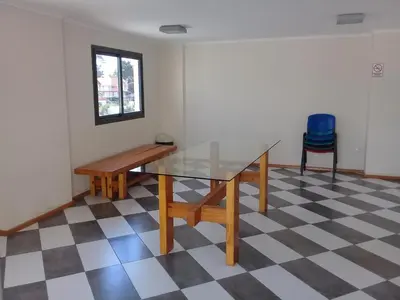 a glass table and bench in a room with a checkered floor at Departamento en Carlos Paz para familias in Villa Carlos Paz