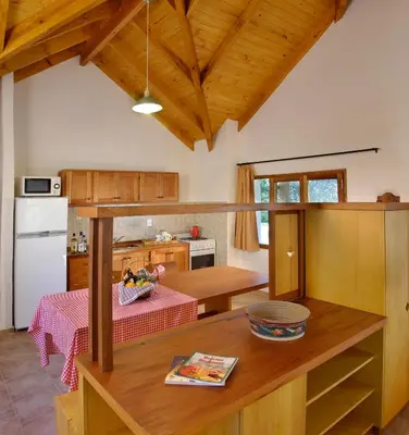 a kitchen with a table and a counter top at Cabañas Am Bach in Villa General Belgrano