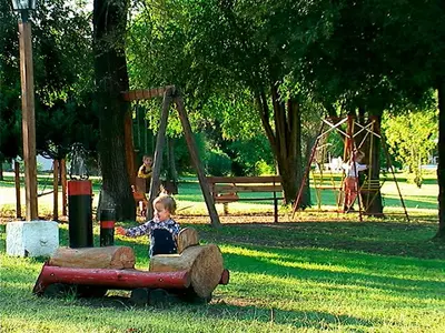 a young child playing in a toy car in a park at Cabañas Am Bach in Villa General Belgrano