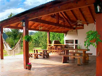 a patio with picnic tables and a hammock at Cabañas Am Bach in Villa General Belgrano