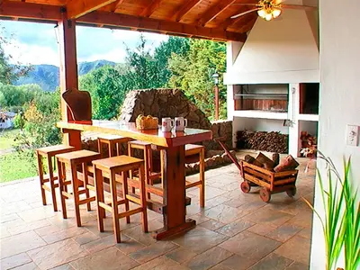 a wooden table and chairs on a patio at Cabañas Am Bach in Villa General Belgrano