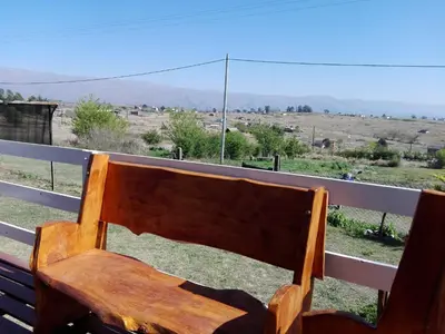 a wooden bench sitting on top of a porch at CABAÑAS LA GUADALUPE in Villa Yacanto
