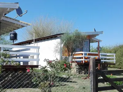 a fence in front of a house with a gate at CABAÑAS LA GUADALUPE in Villa Yacanto