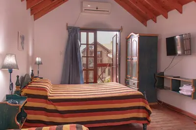 a bedroom with a bed and a large window at Cabañas Euzkadi in Merlo