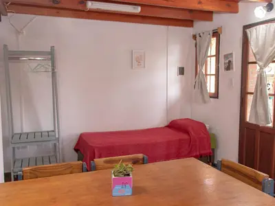 a room with a bed and a table and chairs at Cabañas Euzkadi in Merlo