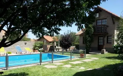 a swimming pool in the yard of a house at Cabañas Euzkadi in Merlo