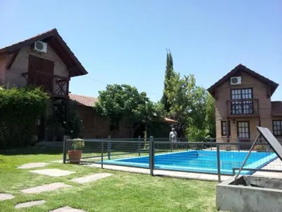 a house with a swimming pool in front of a house at Cabañas Euzkadi in Merlo