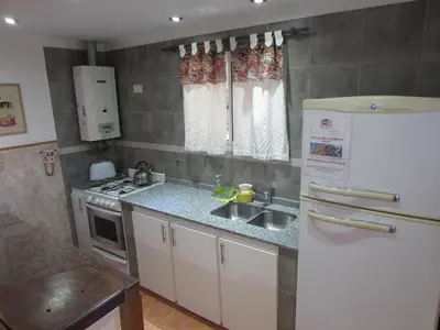 a kitchen with a white refrigerator and a sink at Chalet Individual Maiten 2 in Merlo