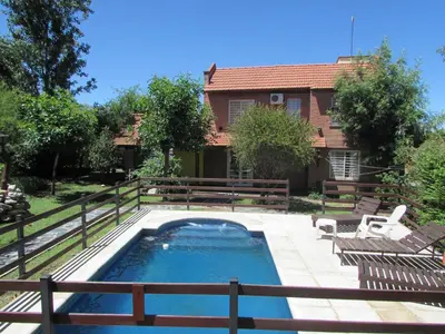 a swimming pool with two chairs and a house at Chalet Individual Maiten 2 in Merlo