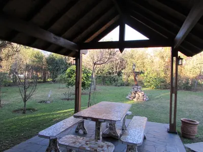 a picnic table and two benches under a pavilion at Chalet Individual Maiten 2 in Merlo