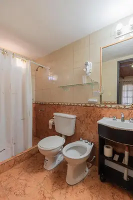a bathroom with a toilet and a sink at Cana Blaya Apart Hotel in Merlo