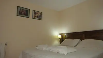 a bedroom with a bed with white sheets and pillows at Cana Blaya Apart Hotel in Merlo