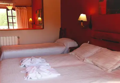 two beds in a hotel room with towels on them at Cana Blaya Apart Hotel in Merlo