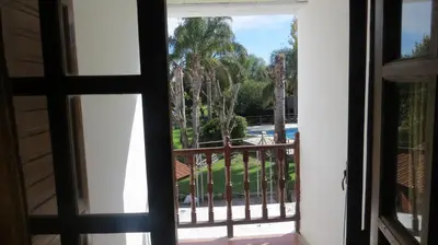 an open door to a balcony with a view of a pool at Cana Blaya Apart Hotel in Merlo
