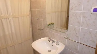a bathroom with a sink and a shower at Cabanas los lirios in Santa Rosa de Calamuchita