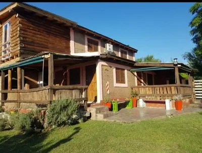 a wooden house with a yard in front of it at Cabañas Kehuen in Villa Amancay