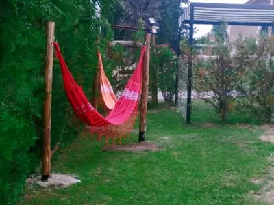 a couple of red hammocks in a yard at Cabañas Kehuen in Villa Amancay